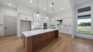 Kitchen with white cabinetry, a kitchen island, b