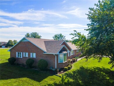 View of property exterior with brick siding, roof with shingles, and a lawn