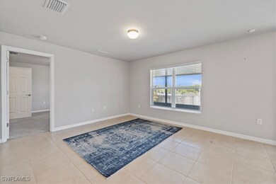 Spare room with light tile patterned floors, visible vents, and baseboards
