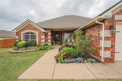 View of front of home featuring a shingled roof, brick siding, and an attached garage