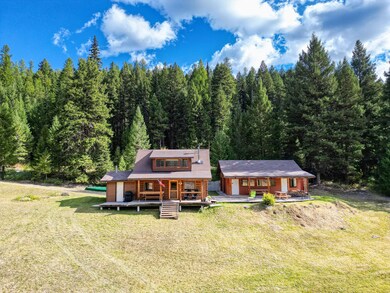 View of back of cabin with meadow