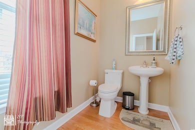 Bathroom with toilet, baseboards, and wood finishe
