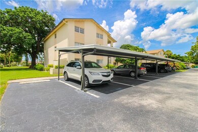 View of car parking with a lawn and a carport
