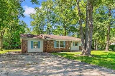 Ranch-style house with brick siding, driveway, and a front lawn
