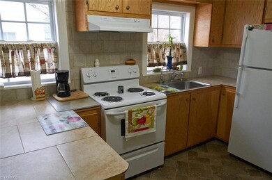 Kitchen has updated vinyl floors and tile counters.  Refrigerator remains!