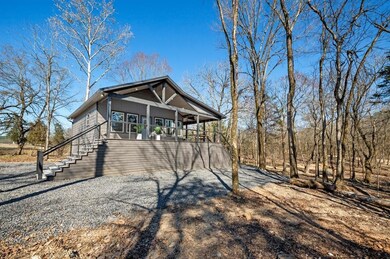 View of home's exterior with gravel driveway, cove