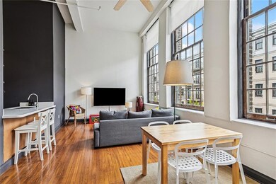 This view shows the dining table as well as bar stools. Look at those gorgeous wood floors which have been stunningly renovated.