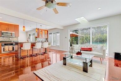 Living room with a skylight, ceiling fan, and ligh