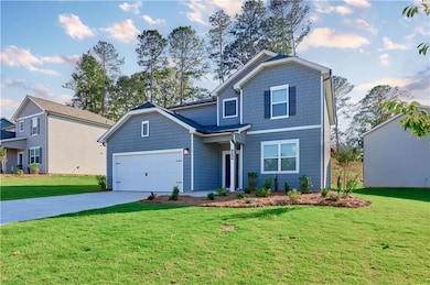 View of front of home with concrete driveway and a front lawn