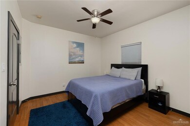 Bedroom featuring a ceiling fan, baseboards, and light wood-style floors