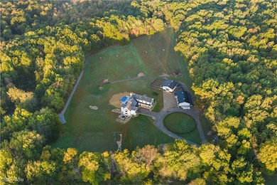 Aerial view of property and surrounding area featuring a heavily wooded area