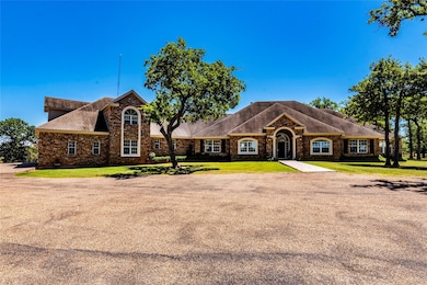 View of front facade with a shingled roof, stone 