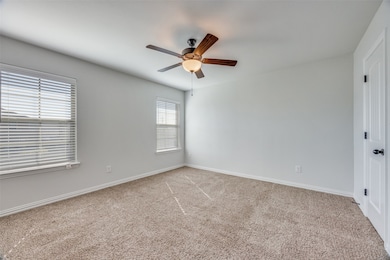Spare room with light carpet and a ceiling fan