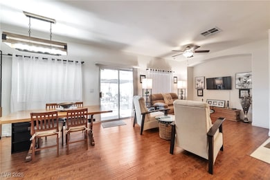 Open Area - Living room Doors to the backyard -featuring wood finished floors and ceiling fan