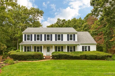 Colonial home with covered porch and a front yard