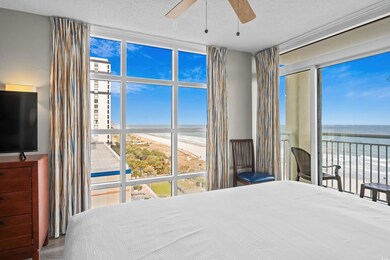 Bedroom with a water view, expansive windows, multiple windows, and a view of the beach