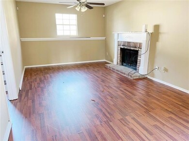 Unfurnished living room with a ceiling fan, a brick fireplace, wood finished floors, and baseboards