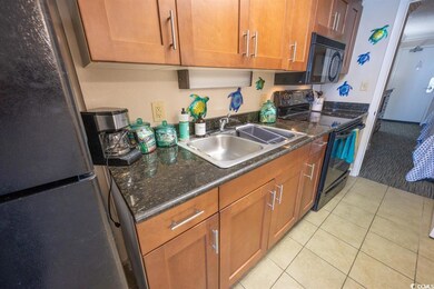 Kitchen with dark stone countertops, sink, black a