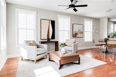 Sitting room featuring ceiling fan and light hardw