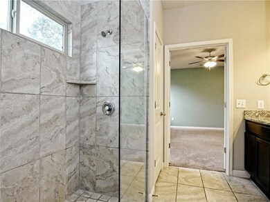 Bathroom featuring vanity, a ceiling fan, and a t