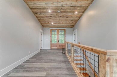 Hallway with wooden ceiling, french doors, light wood finished floors, recessed lighting, and an upstairs landing