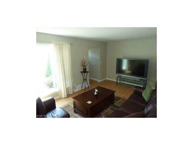 Living room  freshly painted, hardwood flooring, newer entry door in foyer area,