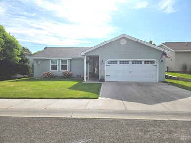 Ranch-style home featuring an attached garage, concrete driveway, and a front lawn