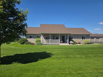 Front of property featuring covered porch, roof with shingles, and a yard