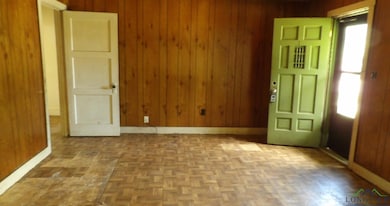 Empty room with wooden walls and baseboards