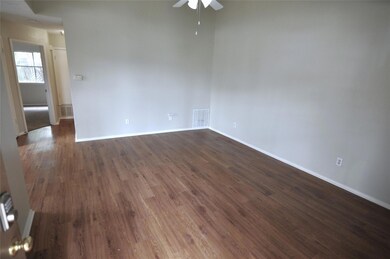 Empty room featuring ceiling fan and dark wood-st