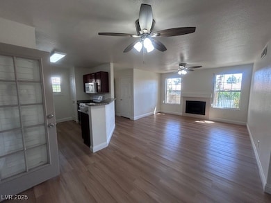 Unfurnished living room featuring ceiling fan, a f