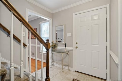 Foyer has tile flooring, coat closet, chair railin