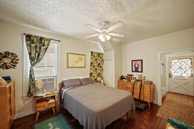 The primary bedroom has hardwood flooring, ceiling