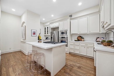 [Kitchen] Stainless steel french door refrigerator/freezer, built-in wall oven and microwave, gas cooktop.