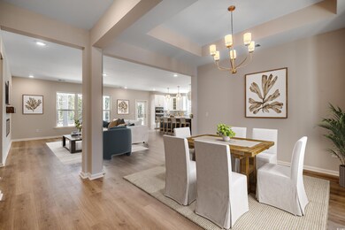 Dining area featuring a chandelier, recessed lighting, light wood-style floors, and a tray ceiling