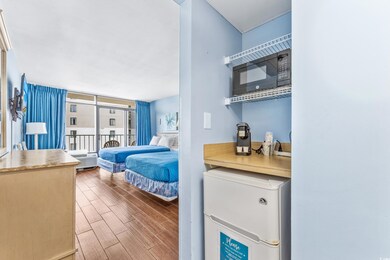 Bedroom featuring expansive windows, white refrige