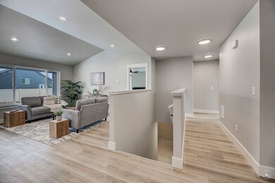 Hallway featuring an upstairs landing, recessed lighting, light wood-style flooring, and lofted ceiling