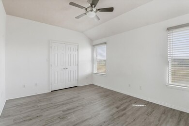Unfurnished bedroom with wood finished floors, vaulted ceiling, ceiling fan, and a closet