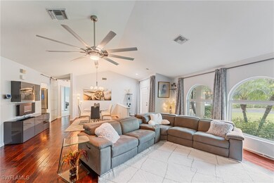 Living room featuring lofted ceiling, wood-type fl