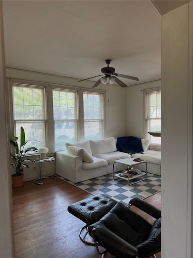 Living area with ceiling fan and wood finished fl