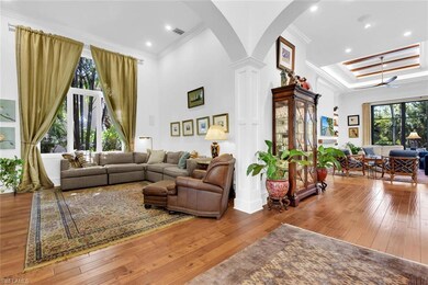 Living area with crown molding, arched walkways, o