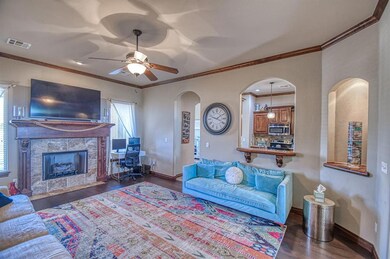 Living w/crown moulding, rolled wood shelving & tr