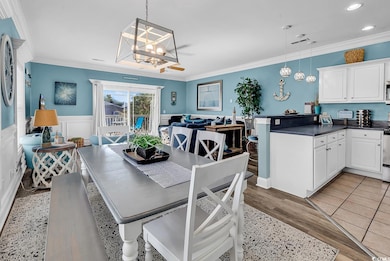Dining area featuring ornamental molding, a chandelier, wainscoting, and recessed lighting