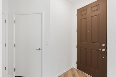 Foyer with light wood-style flooring and baseboar