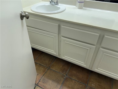 Bathroom featuring vanity and dark tile patterned floors