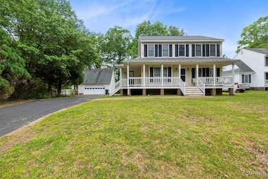 Colonial-style house featuring a garage, covered p