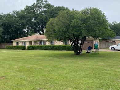 View of yard featuring an attached garage and fenc