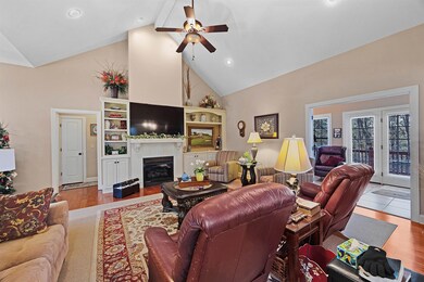 Living room featuring beamed ceiling, ceiling fan,