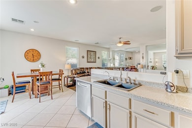 Kitchen featuring a peninsula, light tile patterned floors, open floor plan, dishwasher, and a ceiling fan