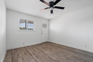 Spare room with dark wood-style flooring and ceiling fan